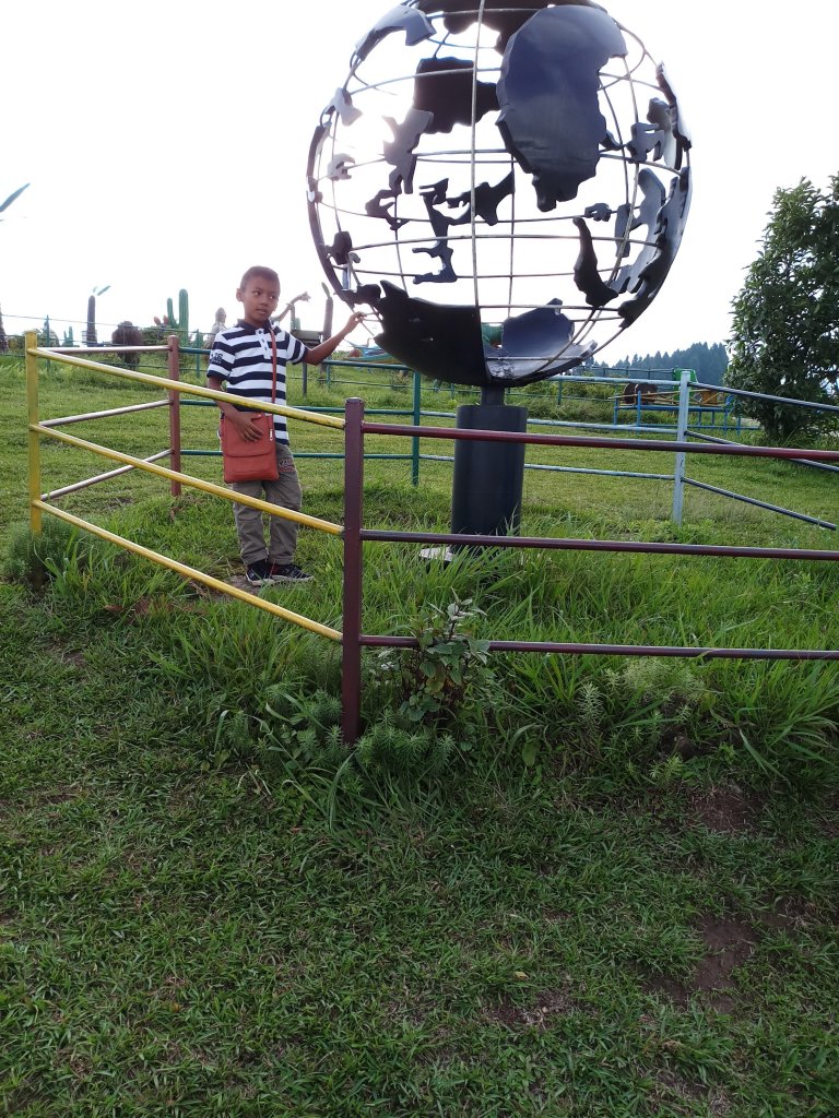 Kids outside a science center in kalimpong standing near globe